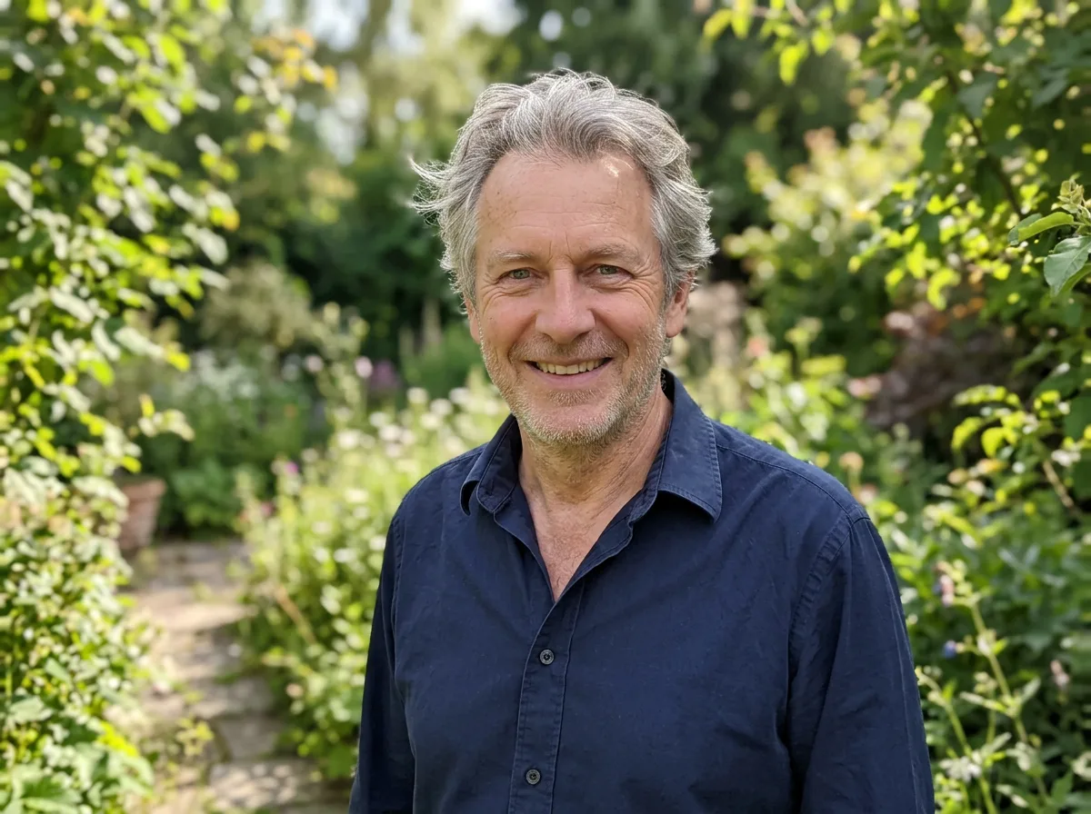 A candid garden photograph of a smiling man in his sixties